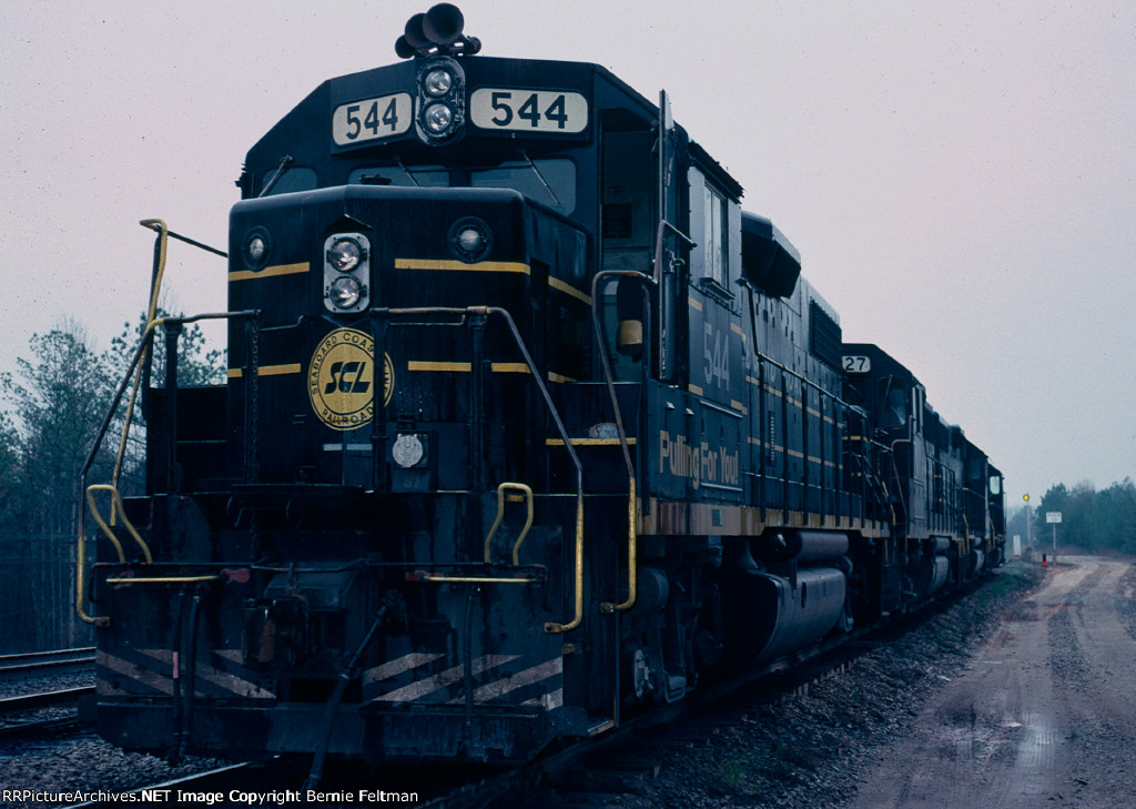 Seaboard Coast Line GP38-2 #544, tied down on the south end of #1 track.  In the distance, the searchlight signal displays a restricted proceed for a departing southbound and the dwarf signal displays a stop indication for the siding 